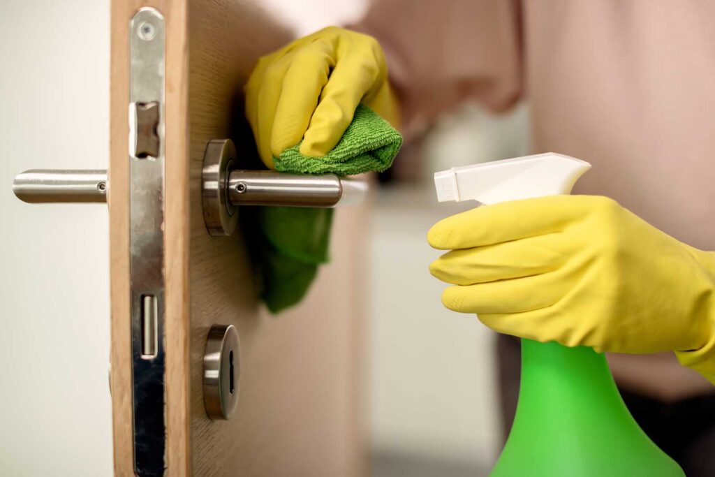 Detailed closeup cleaner disinfecting door handle - Hetty Keeps Clean